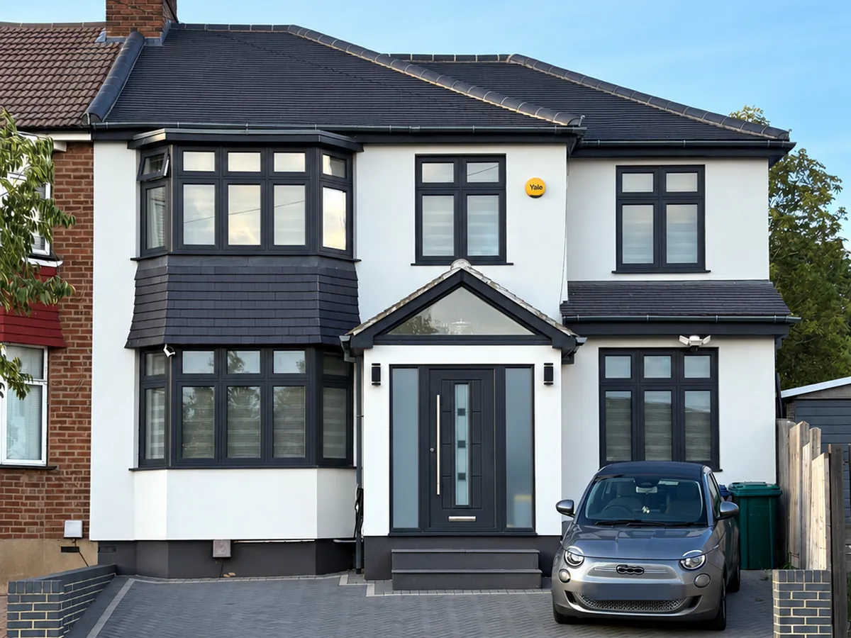 The same Barnet semi finished with external wall insulation and a smooth white render, dark tile-hung bay panel kept