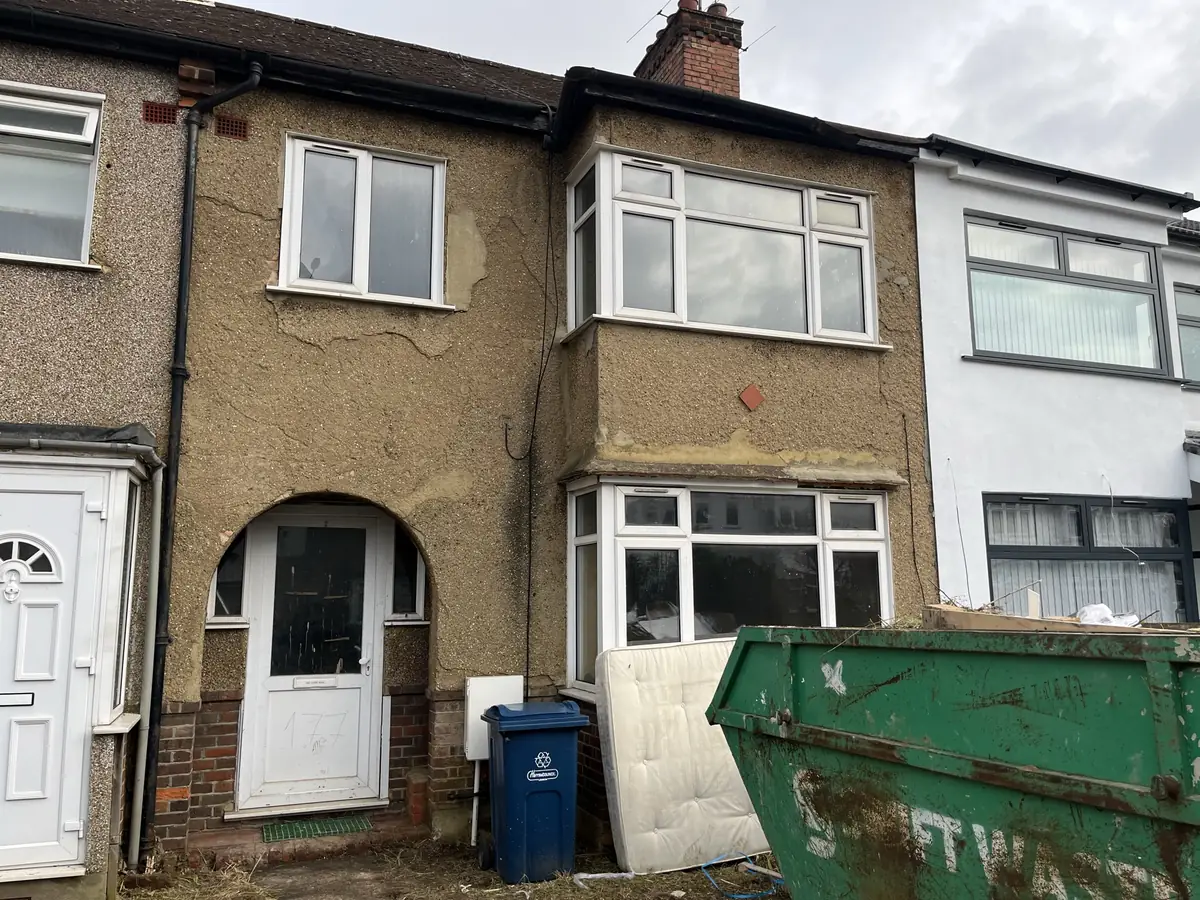 Interwar London terrace with badly cracked and blown pebbledash render before repair work