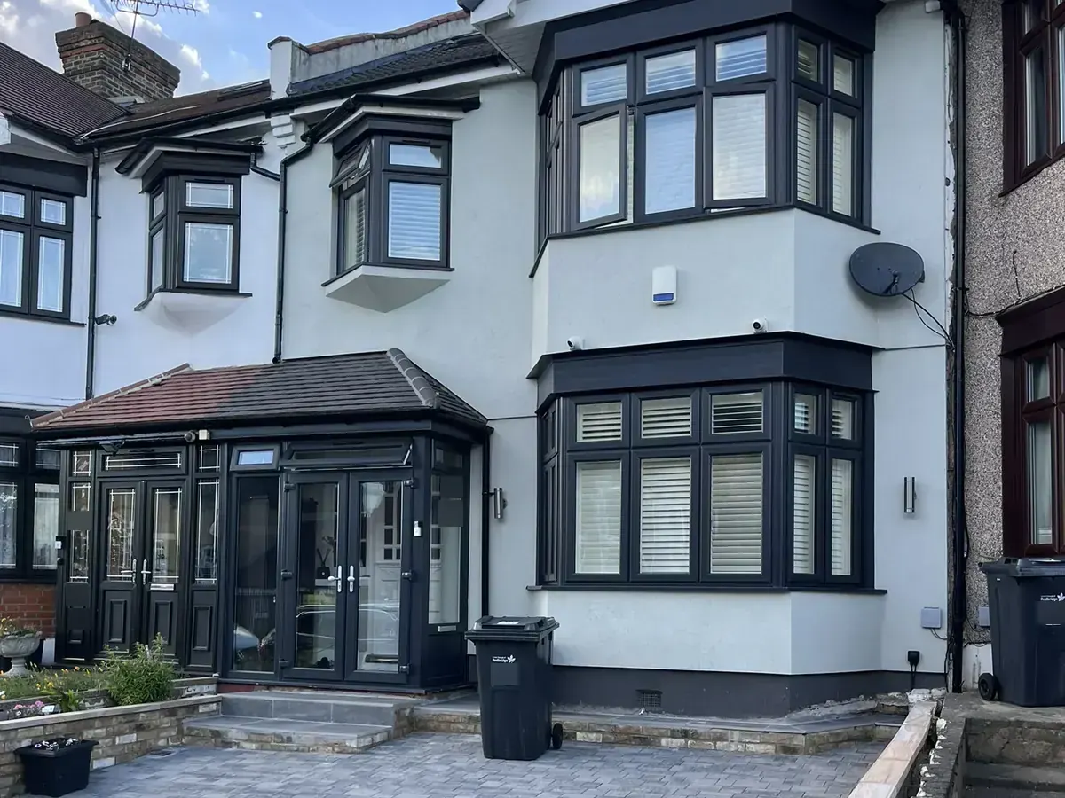 The same Ilford terrace finished in light grey silicone render with dark window frames