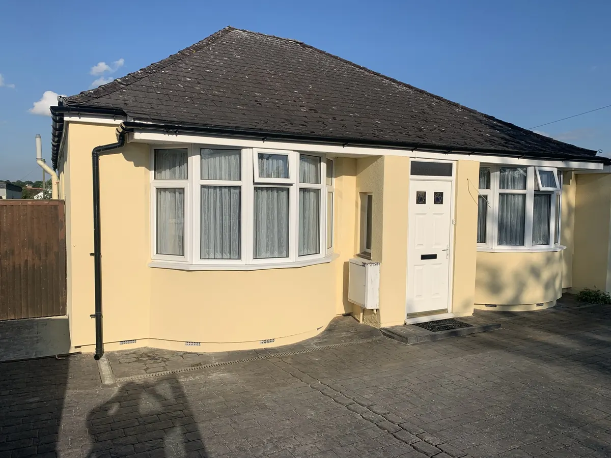 The same Hertfordshire bungalow finished in a pale yellow render over external wall insulation