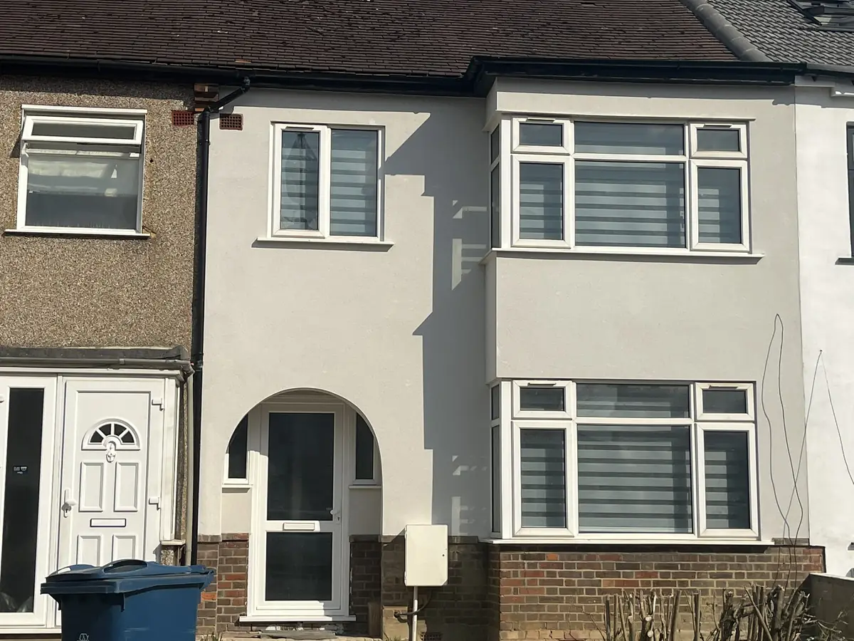 Terraced London home with a new smooth render finish beside a neighbouring property still in original pebbledash