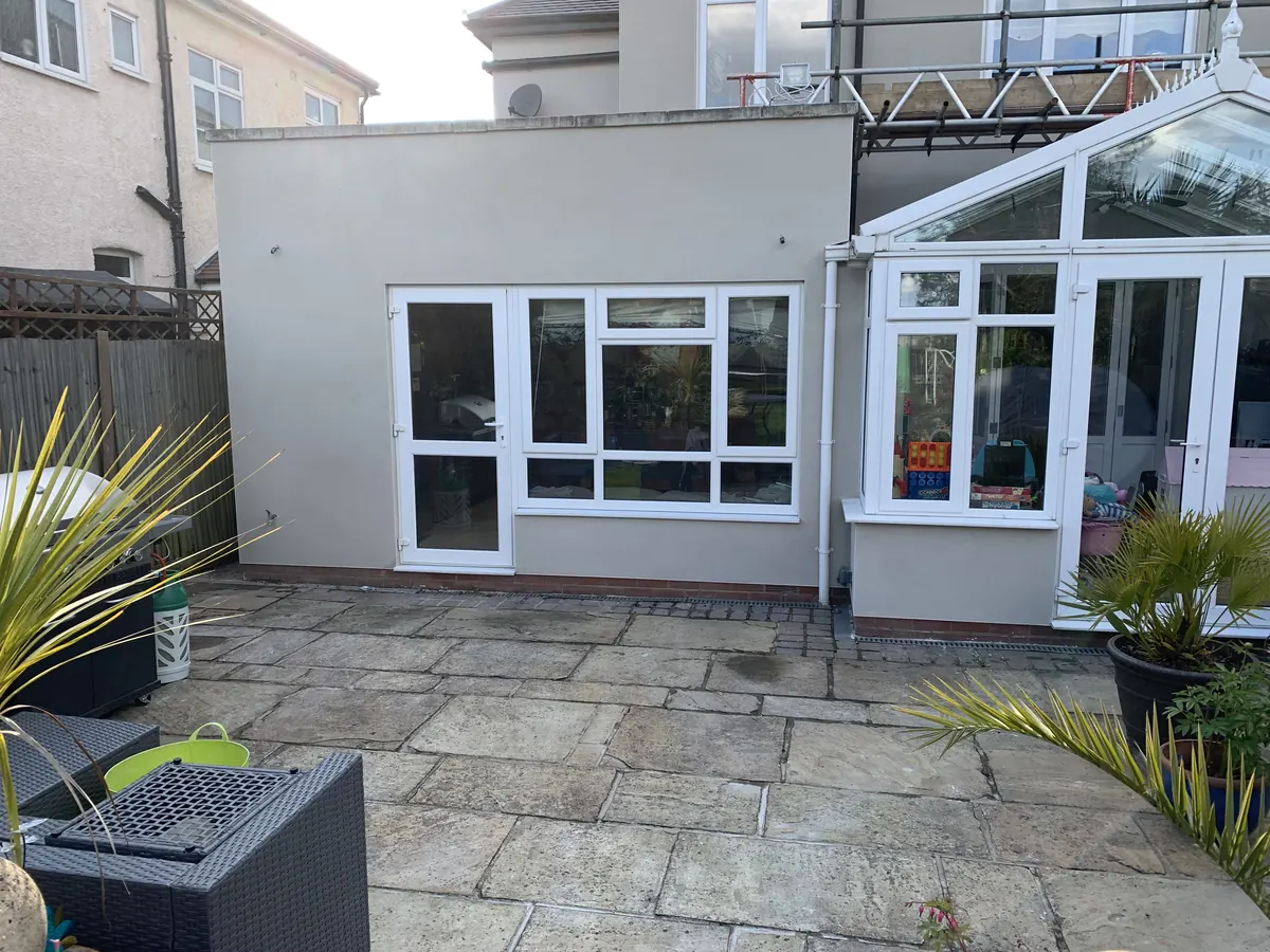 Rear extension of a South London house with a new smooth render finish beside a conservatory