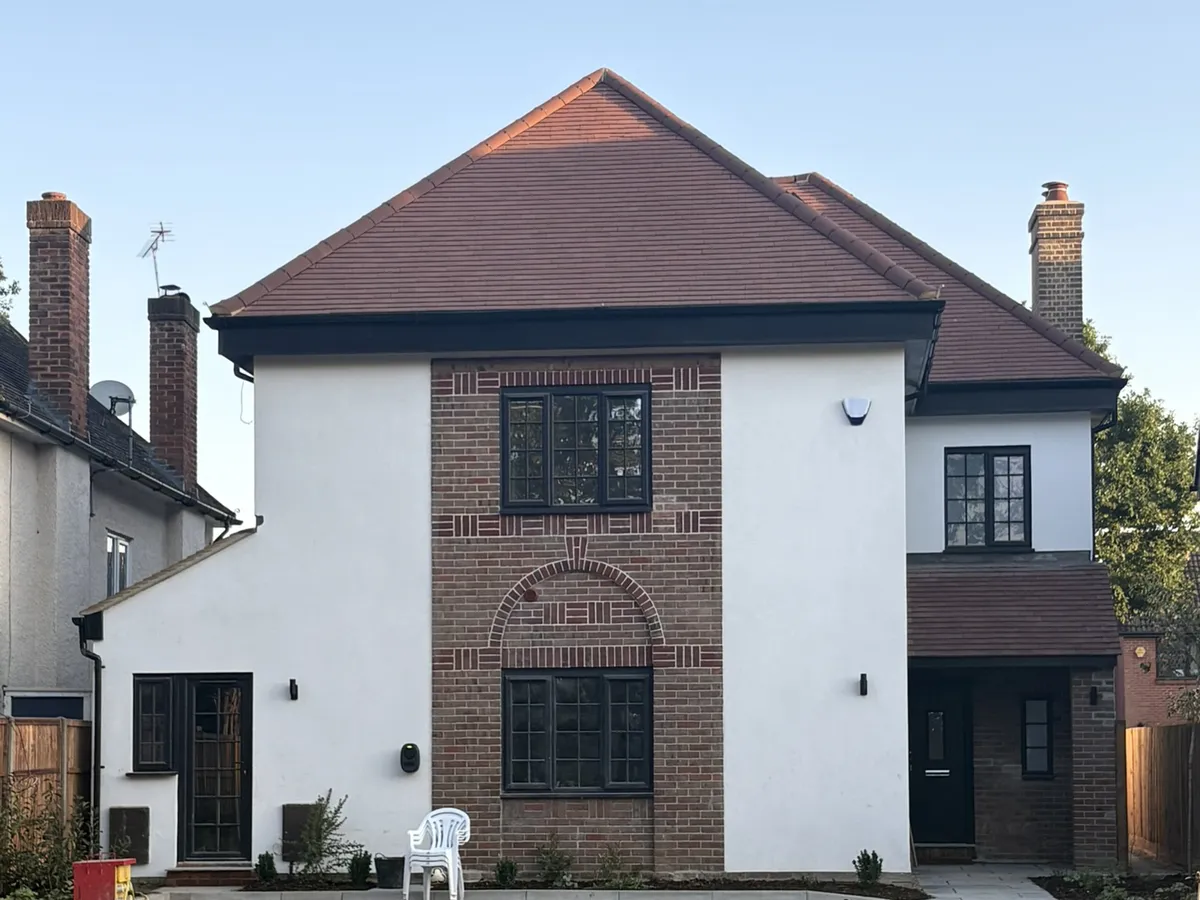 Front of a detached house in St Albans finished in white render either side of a decorative brick panel