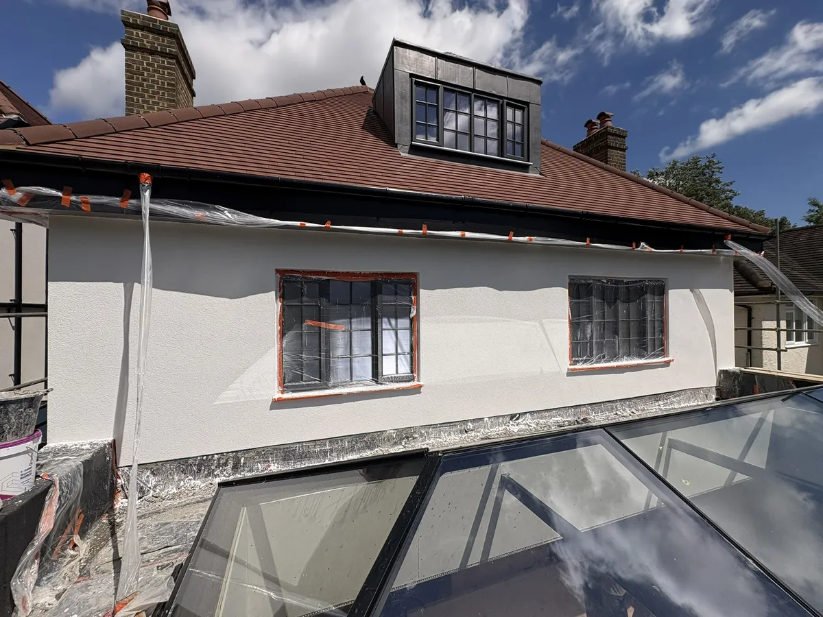 Side of a St Albans house finished in white render, with the window masking still in place and a roof lantern in front